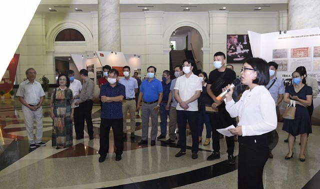 Các đại biểu tham quan và nghe giới thiệu về các tư liệu, hiện vật được trưng bày.