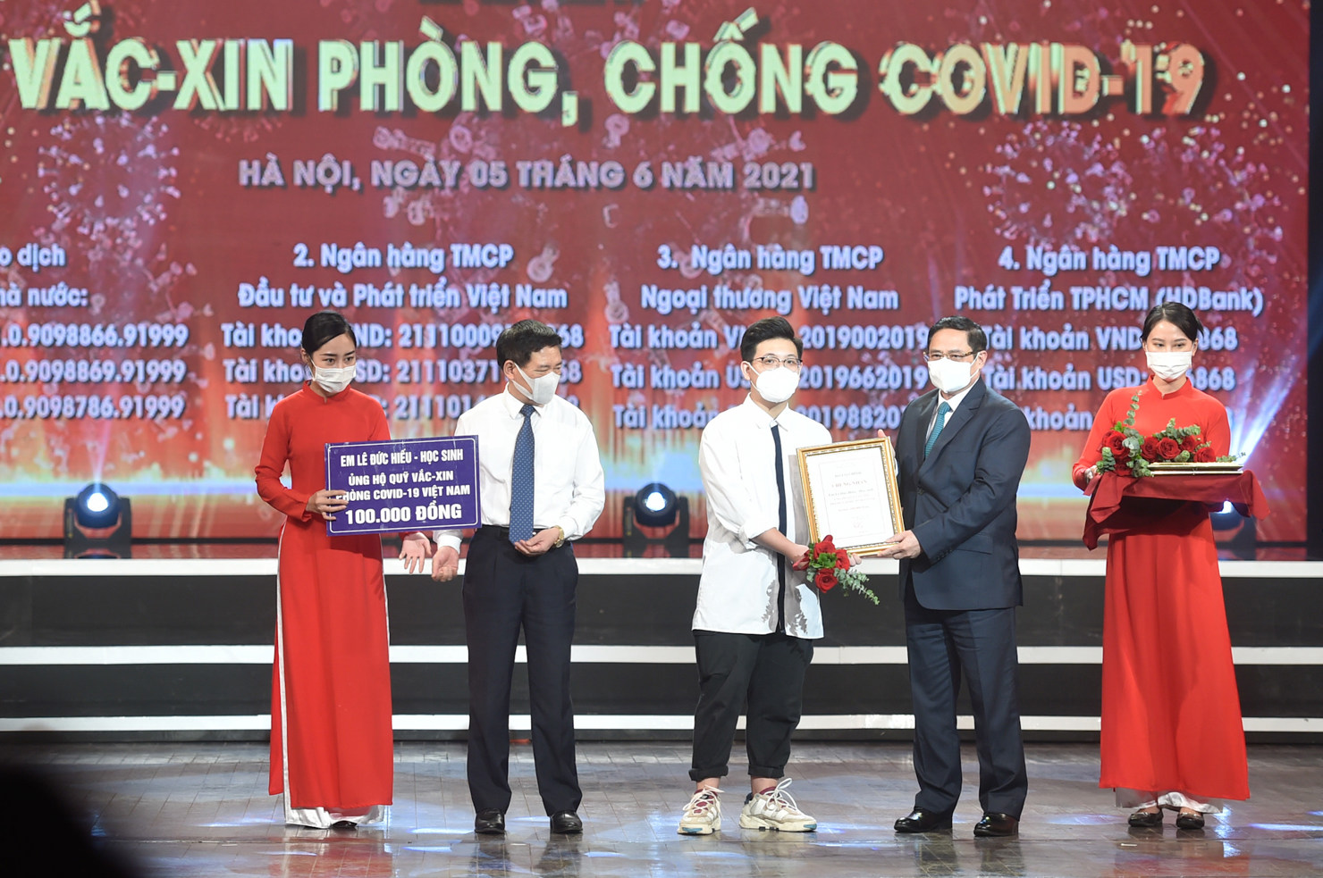 Thủ tướng Chính phủ Phạm Minh Chính trao chứng nhận, hoa cảm ơn em Lê Đức Hiếu, học sinh Trường Phạm Hồng Thái, Ba Đình, Hà Nội. Ảnh: VGP
