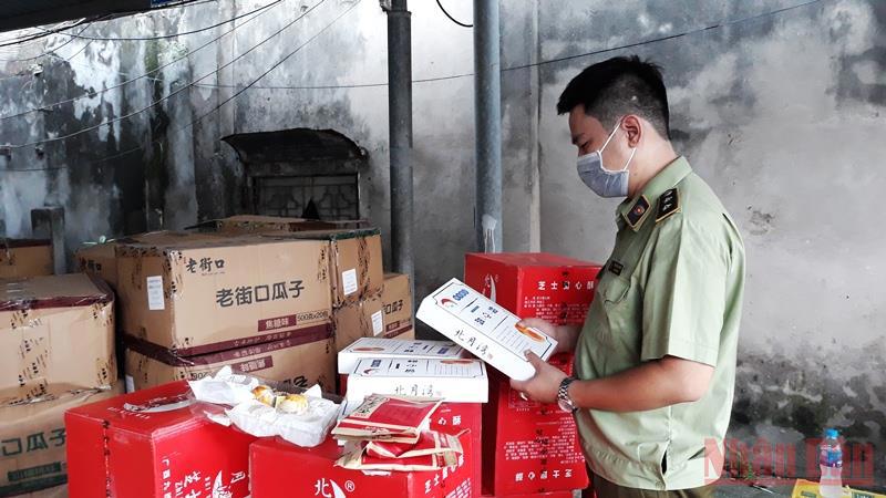 Cán bộ quản lý thị trường kiểm tra chất lượng sản phẩm bánh, kẹo nhập khẩu. (Ảnh: Nguyên Trang)