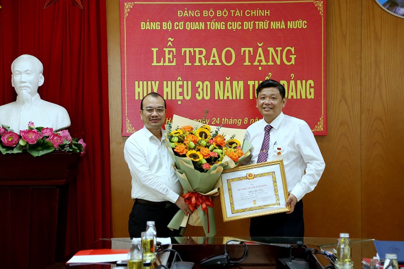 Đồng chí Phạm Vũ Anh - Phó Bí thư Đảng ủy, Phó Tổng cục trưởng Tổng cục DTNN trao Huy hiệu 30 năm tuổi Đảng cho đồng chí Phan Anh Tuấn - Bí thư Chi bộ, Vụ trưởng Vụ Khoa học và Công nghệ bảo quản. Ảnh: Văn Trường.