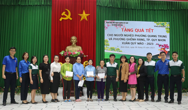 Ông Nguyễn Tấn Chúc - Phó Chủ tịch Công đoàn Vietcombank Bình Định (thứ 7 từ phải sang) cùng đại diện Chi đoàn Vietcombank Bình Định tặng quà cho bà con nghèo phường Quang Trung và phường Ghềnh Ráng