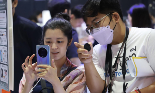 Một du khách kiểm tra điện thoại di động tại Mobile Expo 2023, Bangkok.