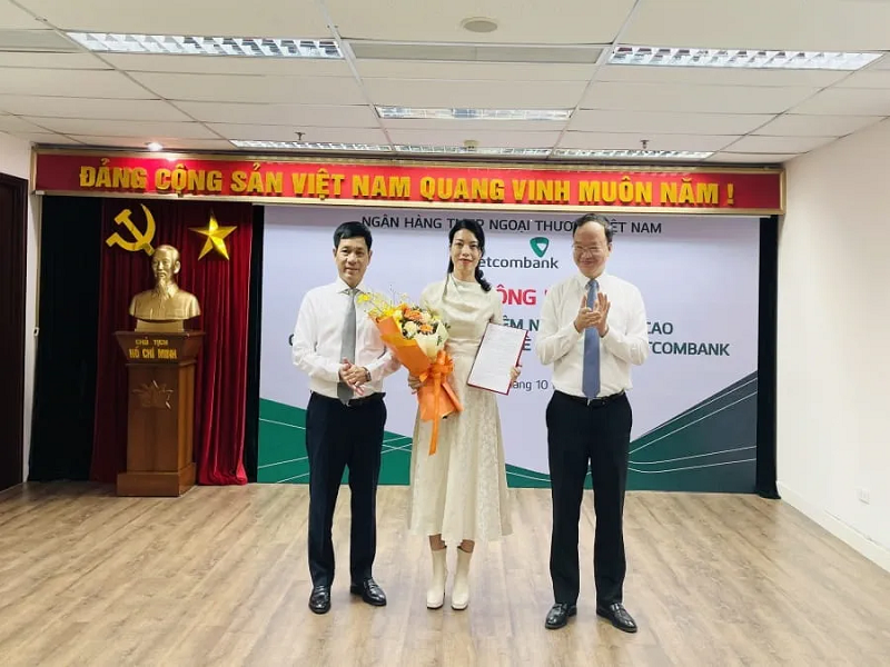 Phó Tổng Giám đốc Vietcombank Lê Quang Vinh (bên phải) trao quyết định và ông Nguyễn Trung Hà - Chủ tịch HĐTV VCBL (bên trái) tặng hoa chúc mừng bà Nguyễn Ngọc Trâm -  tân Thành viên HĐTV VCBL  