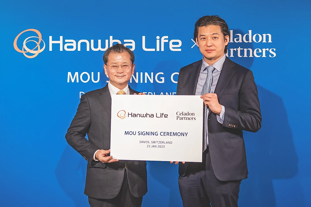 Ông Yeo Seung Joo - Phó Chủ tịch kiêm CEO của Hanwha Life Hàn Quốc (bên trái) và ông Donald Tang - CEO của Celadon Partners (bên phải) ký kết Biên bản ghi nhớ về đổi mới AI tại Diễn đàn Kinh tế Thế giới ở Davos (Thụy Sĩ).