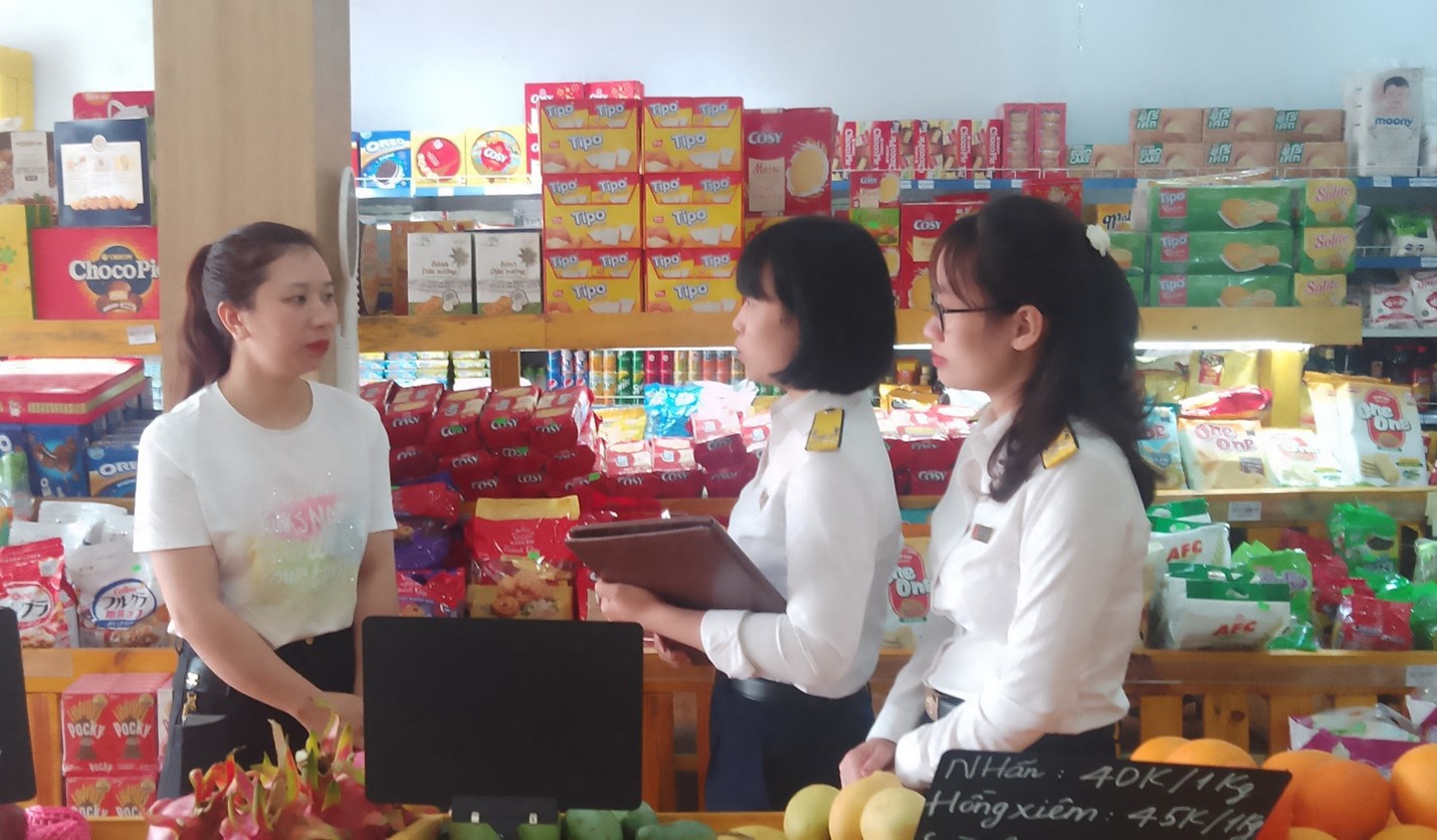 Cán bộ thuế hỗ trợ hộ kinh doanh thực hiện hóa đơn điện tử từ máy tính tiền có kết nối với cơ quan thuế.