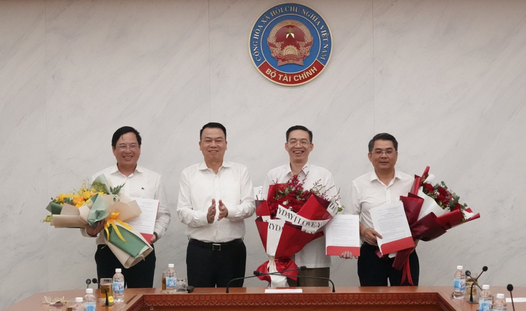 Thứ trưởng Bộ Tài chính Nguyễn Đức Chi trao quyết định và tặng hoa cho các đồng chí được điều động, bổ nhiệm.