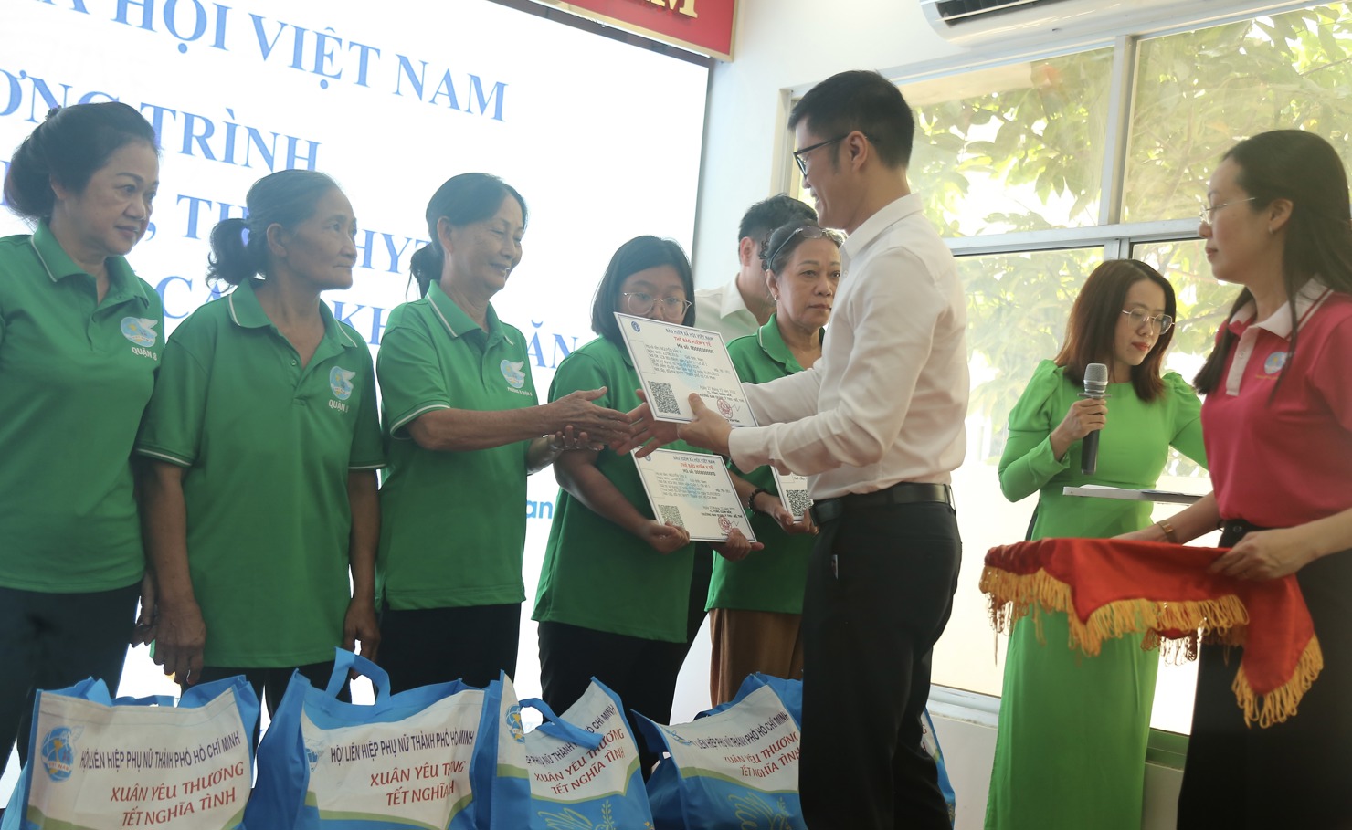 Giám đốc BHXH TP. Hồ Chí Minh Lò Quân Hiệp trao tặng thẻ BHYT cho người dân có hoàn cảnh khó khăn. Ảnh: Lê Văn