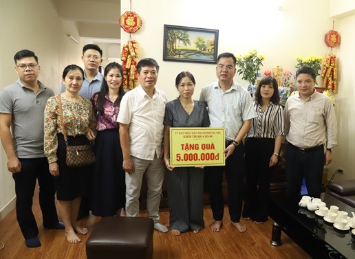 Đồng chí Nguyễn Văn Tường - Phó Giám đốc Kho bạc Nhà nước khu vực I (thứ 3 từ phải sang) cùng các thành viên trong Đoàn công tác tặng quà cho cá nhân có hoàn cảnh khó khăn của BHXH TP. Hà Nội.