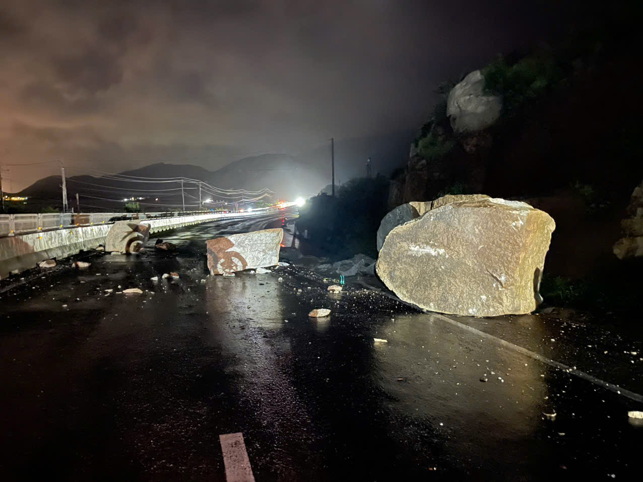 Đất đá từ taluy dương rơi xuống mặt đường tại Km1590 trên Quốc lộ 1 đêm 19/11, các lực lượng triển khai dọn dẹp trong đêm.